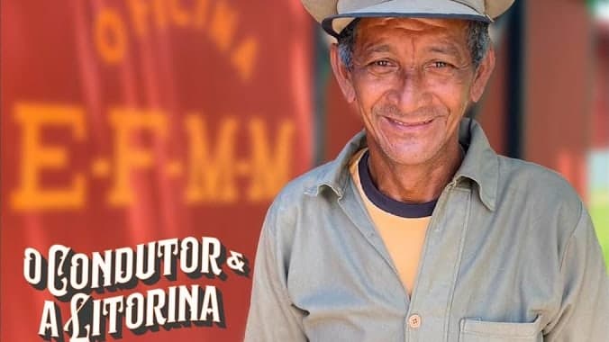 O condutor, de quepe e camisa com o emblema da EF-MM, sorri diante de um vagão vermelho da oficina da Estrada de Ferro Madeira-Mamoré, ao lado do título “O Condutor & a Litorina”.